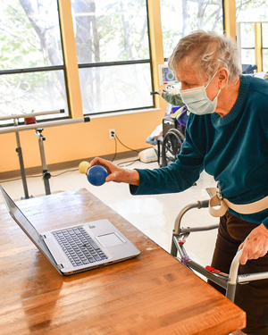 Standing and using RESTORE therapy program at Riverdale Center